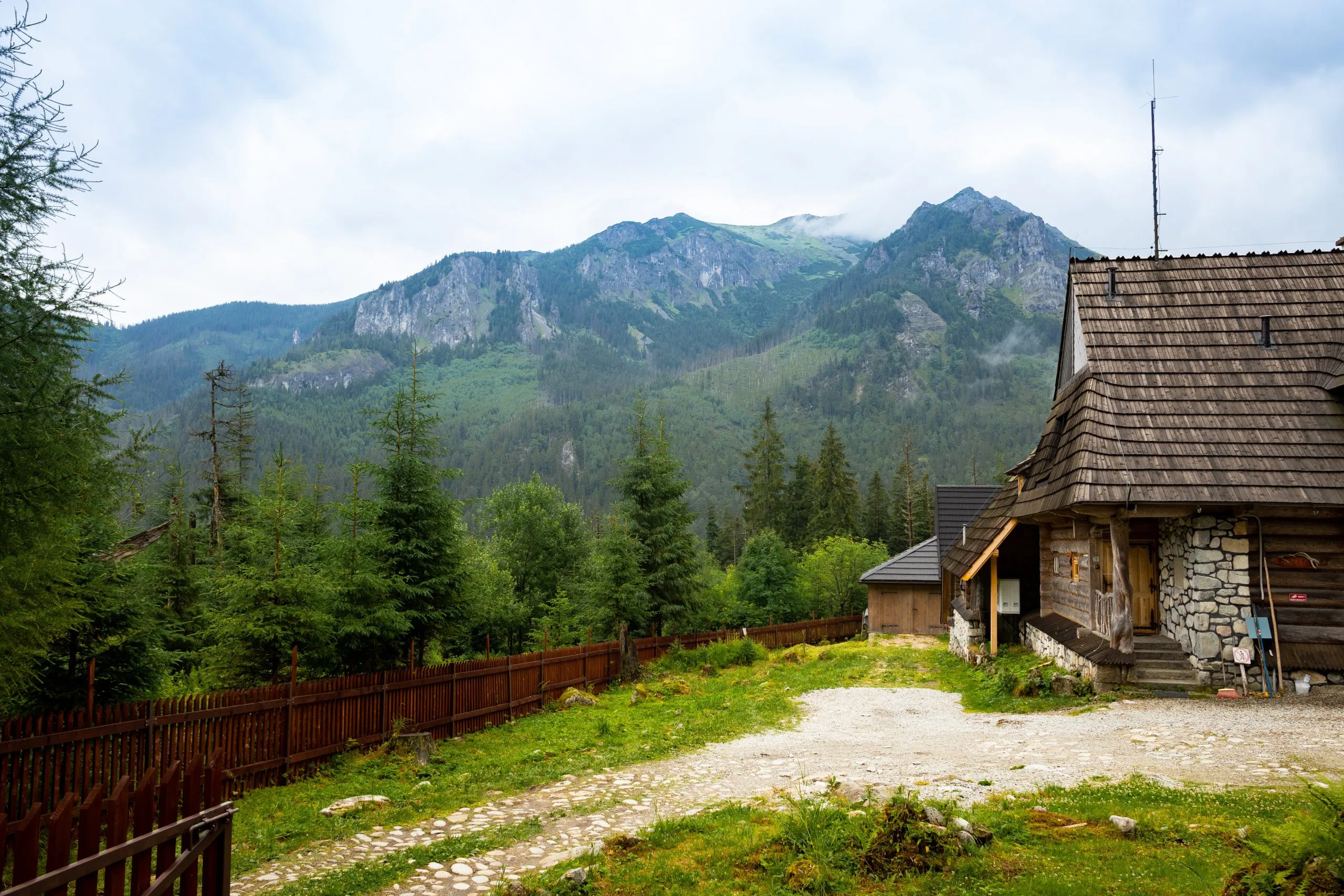 Vieille maison en bois au milieu de la forêt avec les montagnes en toile de fond, près de la route de Morskie Oko, Pologne