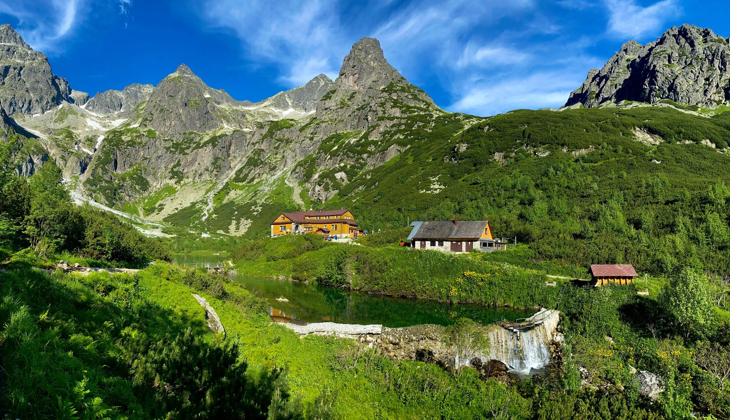Slovakiets landskab. Hytte nær Zelene pleso, Vysoke Tatry NP, Europa. Solrig dag i bjergene. Stenet bakke er sommersæson. Høje Tatra, sø med grøn skov. Rejser i Slovakiet.